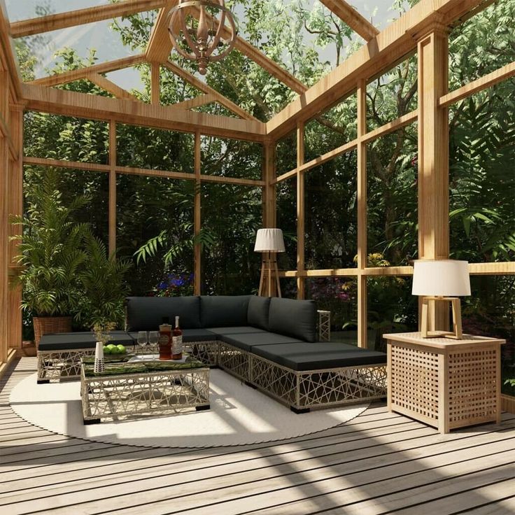 a living room filled with lots of furniture and plants on top of a wooden floor