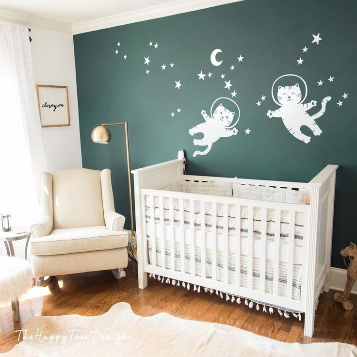 a baby's room with green walls and white furniture