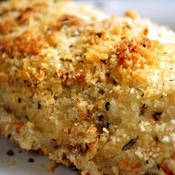 a piece of food on a white plate with parmesan sprinkles