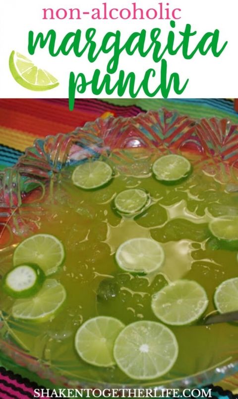 a glass bowl filled with limeade on top of a colorful table cloth next to a spoon