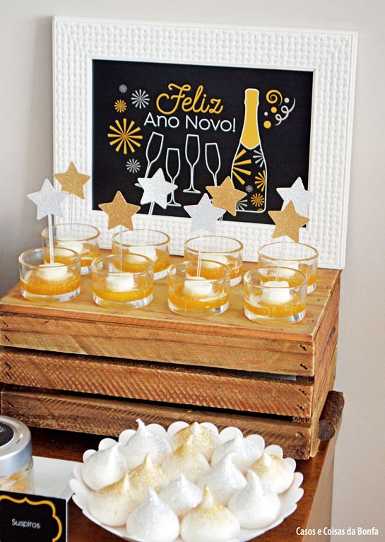 a table topped with drinks and marshmallows on top of a wooden tray