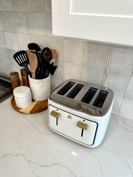 a toaster sitting on top of a counter next to utensils