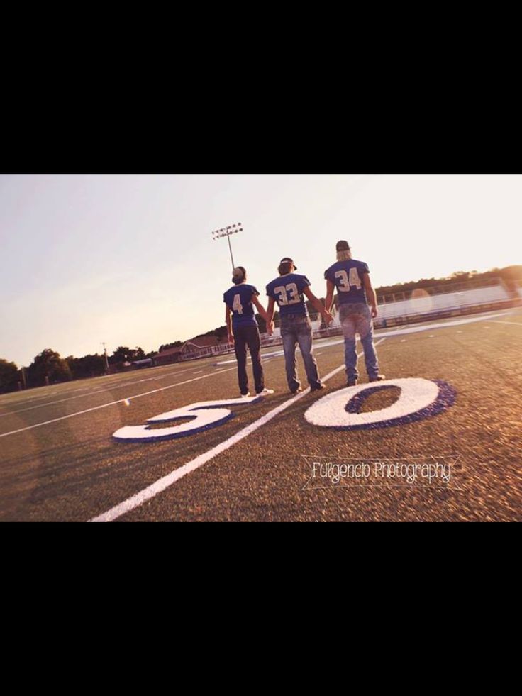 three football players holding hands on the field