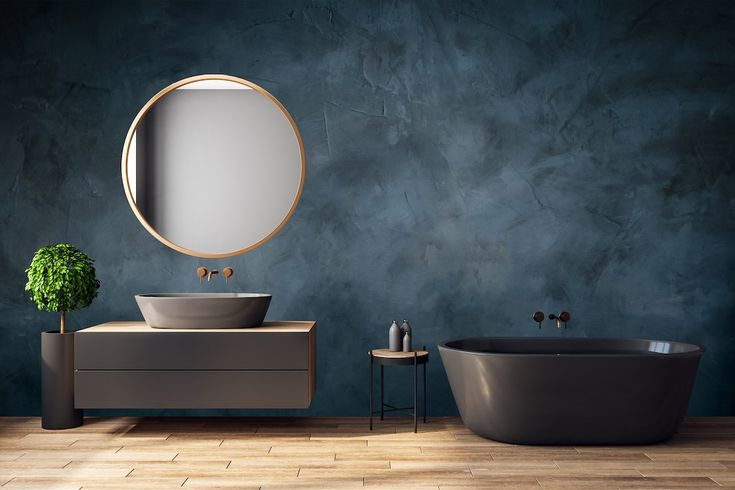 a bathroom with a round mirror above the sink and a bathtub next to it