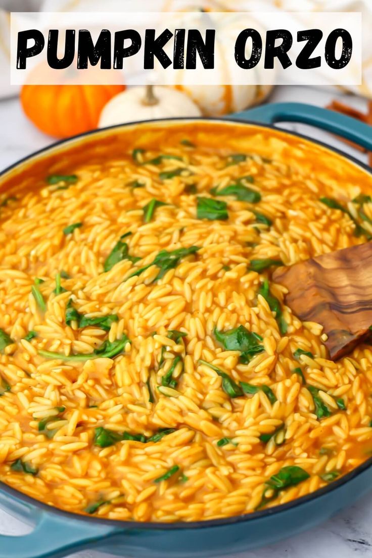 pumpkin orzo in a blue skillet with a wooden spoon on the side and text overlay that reads, pumpkin orzo