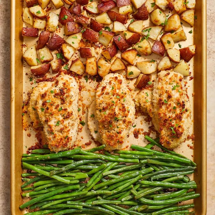 chicken, potatoes and green beans in a baking pan with seasoning sprinkled on top