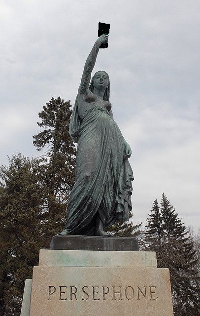 a statue of a woman holding an apple in her right hand and the words persephone on it