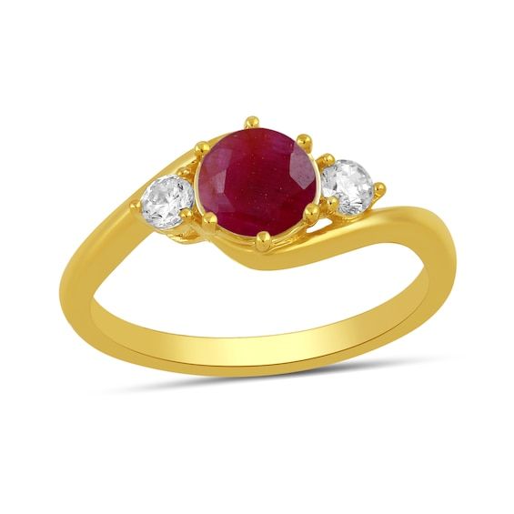 a yellow gold ring with an oval ruby stone and three white diamonds on the side