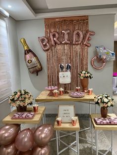 the table is set up with pink and gold balloons, champagne bottles, and flowers