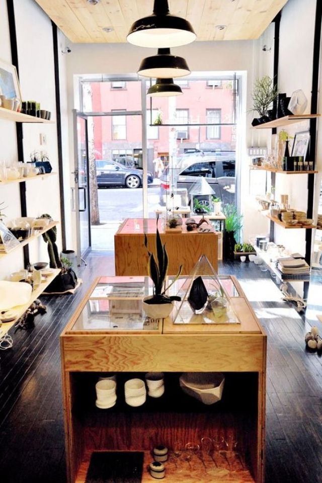 the inside of a shoe store with lots of shoes on shelves and plants in pots