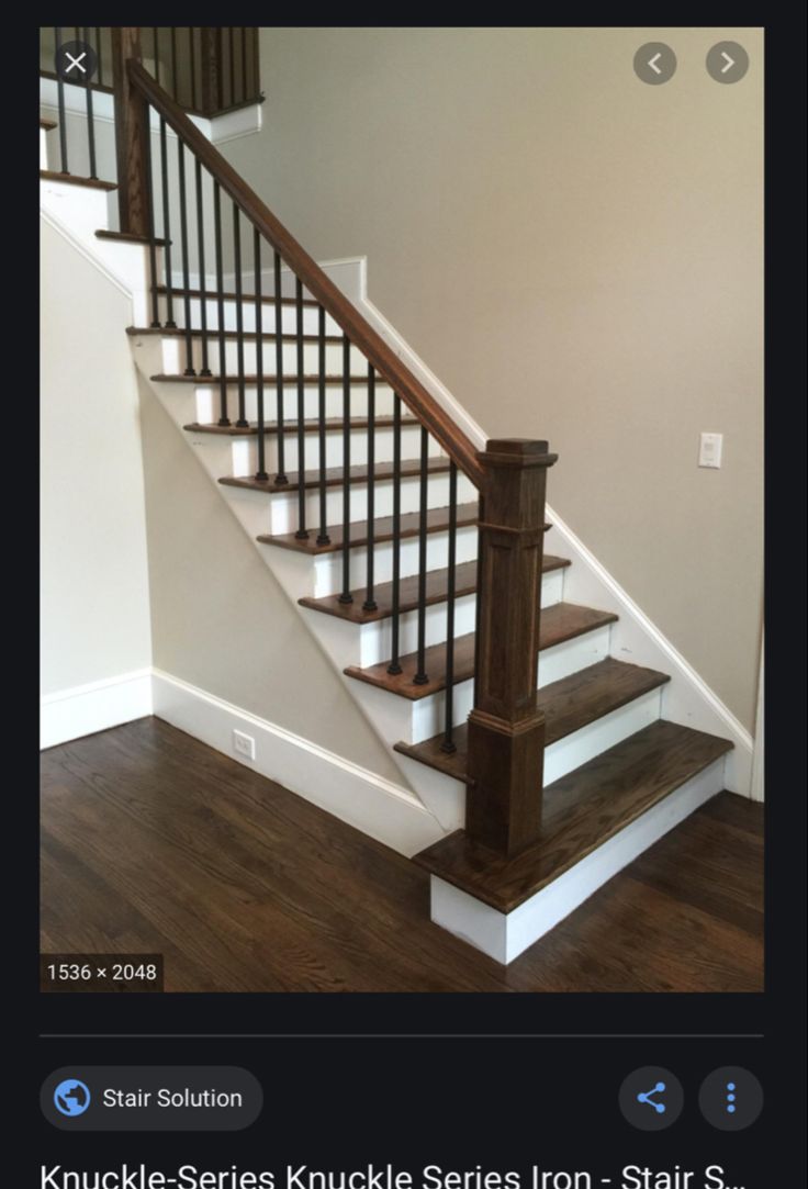 a staircase with white railing and wood handrails