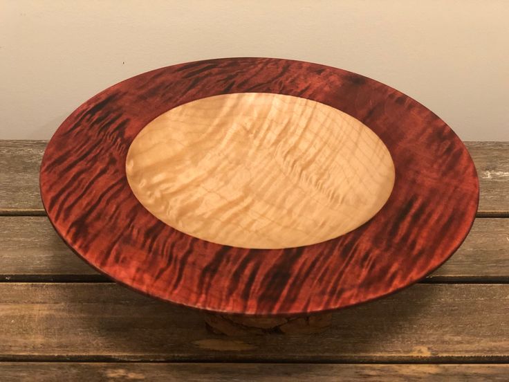 a wooden plate sitting on top of a wooden table next to a brown and white wall