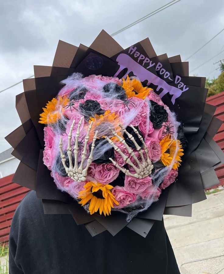 a person wearing a fake skeleton head with flowers on it's face and hands