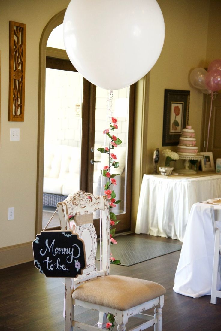 a chair with a sign that says mommy to be on it and balloons in the background