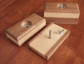 three pieces of wood sitting on top of a wooden table with screws in them