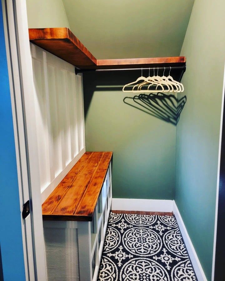 an empty closet with some clothes hanging on the rack and a coat rack in the corner