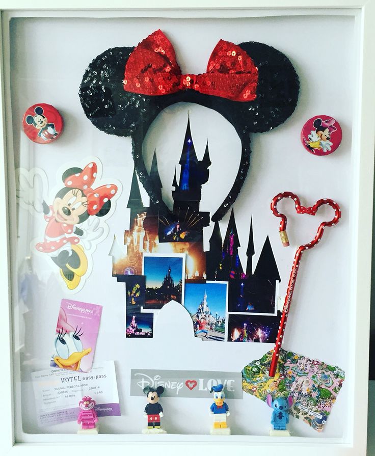 a mickey mouse head and other items are on display in a white frame with red sequins