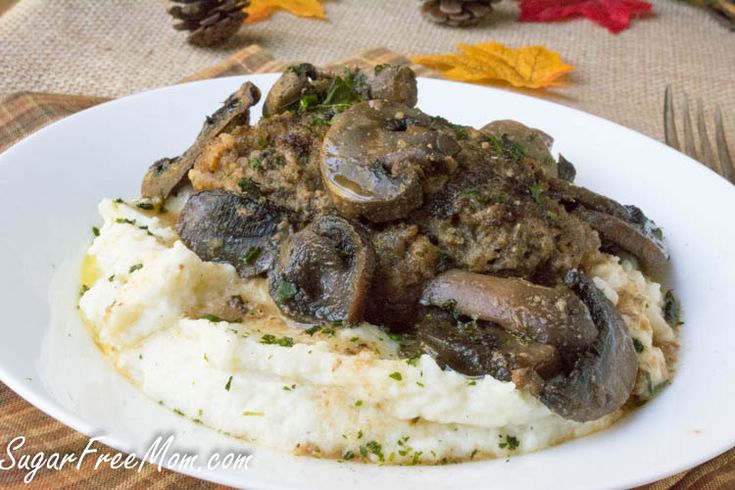 a white plate topped with mashed potatoes and mushrooms