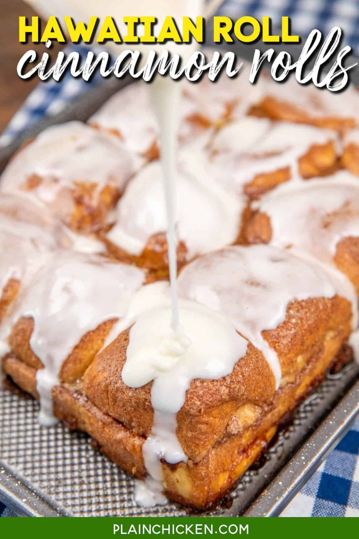 a pan filled with cinnamon rolls covered in icing and being drizzled