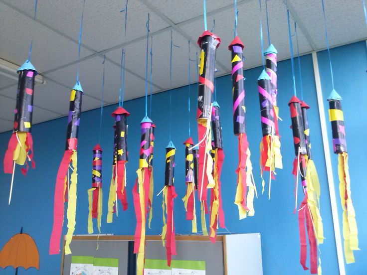 colorful streamers are hanging from the ceiling in an office area with blue walls and umbrellas