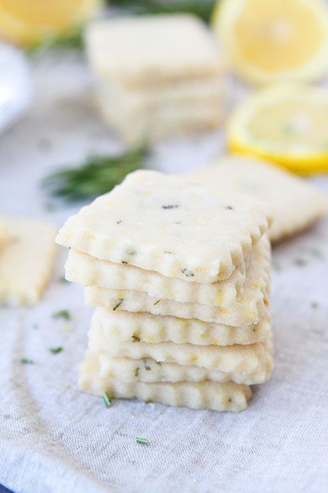 a stack of crackers sitting on top of a table next to lemon wedges