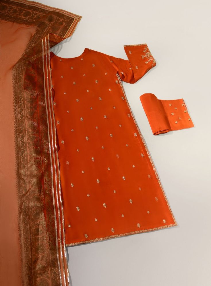 Adorned on pure raw silk 58 Gms, in a deep burnt orange hue intricately embellished with single thread zari and sequins. The length of the long kameez is 46 inches. Styled with gotah phool trousers and a pure organza matching dupatta featuring Agha Noor’s signature hand blocked borders with gotah. An alluring three pie Long Kameez, Agha Noor, S Signature, Raw Silk, Burnt Orange, Festival Season, Borders, Pie, Trousers