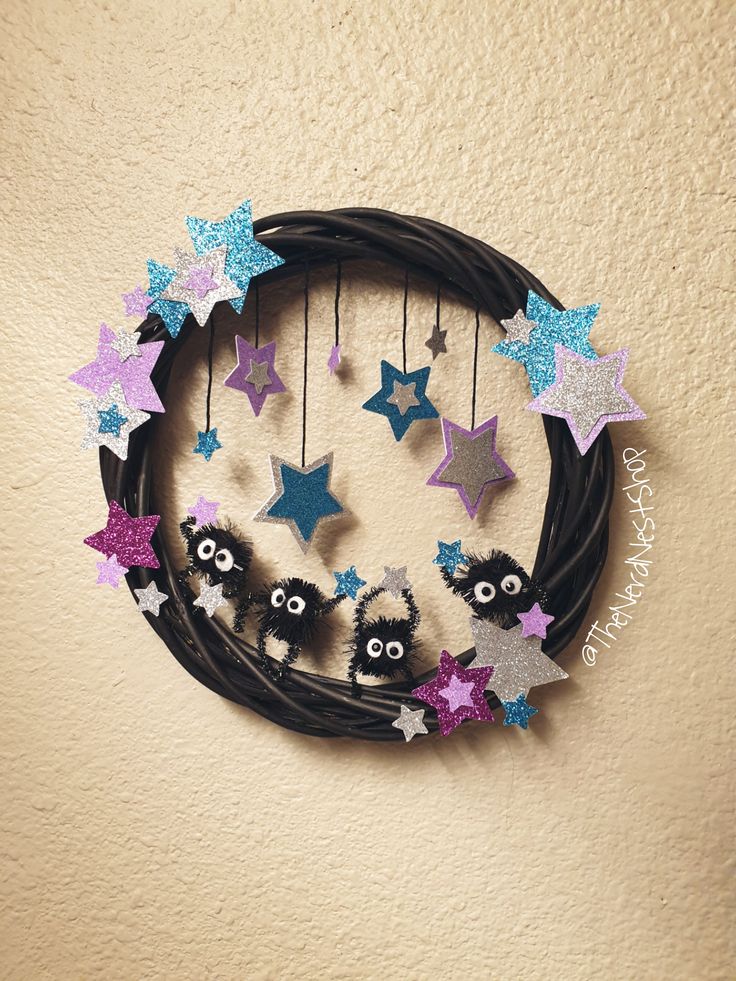 a black wreath with purple, blue and silver stars hanging from it