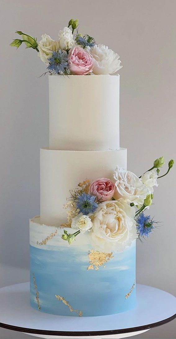 a three tiered cake with flowers on top