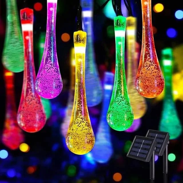 multicolored glass vases hanging from strings with lights in the background