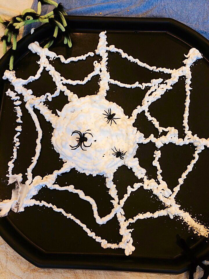 a black tray with white icing and spider webs on it