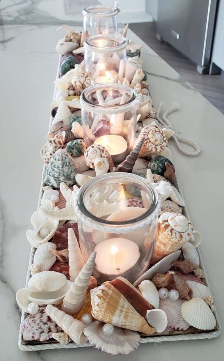 a long table with candles and seashells on it