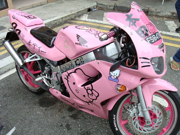 a pink hello kitty motorcycle parked on the street