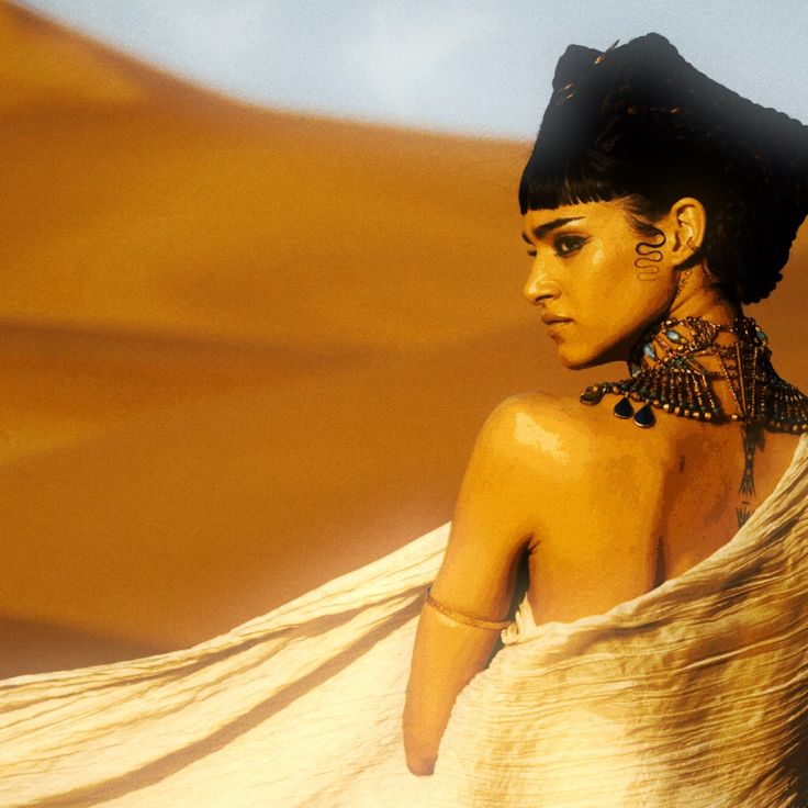 an image of a woman in the desert with her back turned to the camera and wearing jewelry