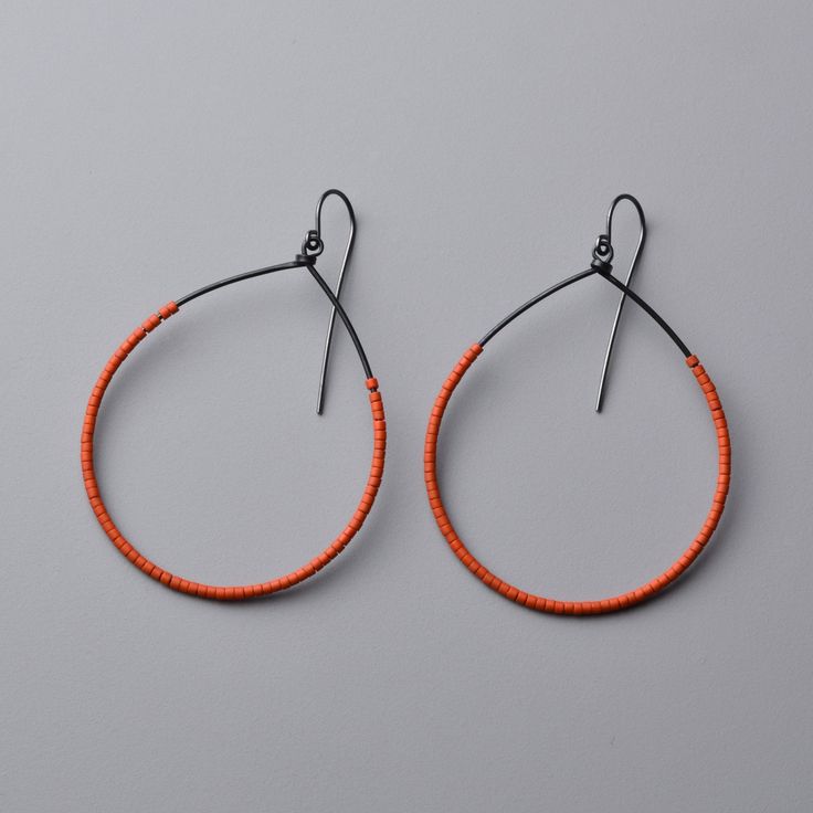 Bead & Steel Earrings - These bold hoops are made with deep orange, glass Miyuki Delica beads strung onto hand-forged steel. They feature oxidized sterling silver ear wires and ship with handmade earring backings for security. Red Seed Bead Earrings, Simple Bead Earrings, Tube Earrings, Wire Earrings Handmade, Orange Jewelry, Miyuki Delica Beads, Beaded Earrings Diy, Earrings Handmade Dangle, Orange Earrings