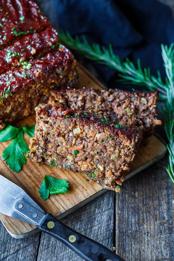 sliced meatloaf on cutting board with knife next to it