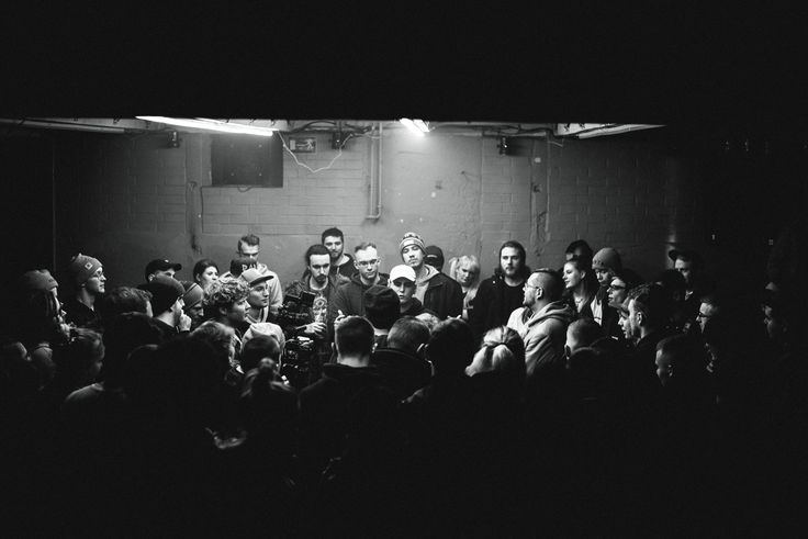 a group of people sitting around each other in a dark room