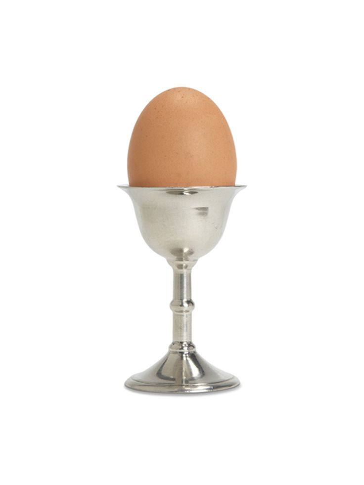 an egg in a metal cup on a white background