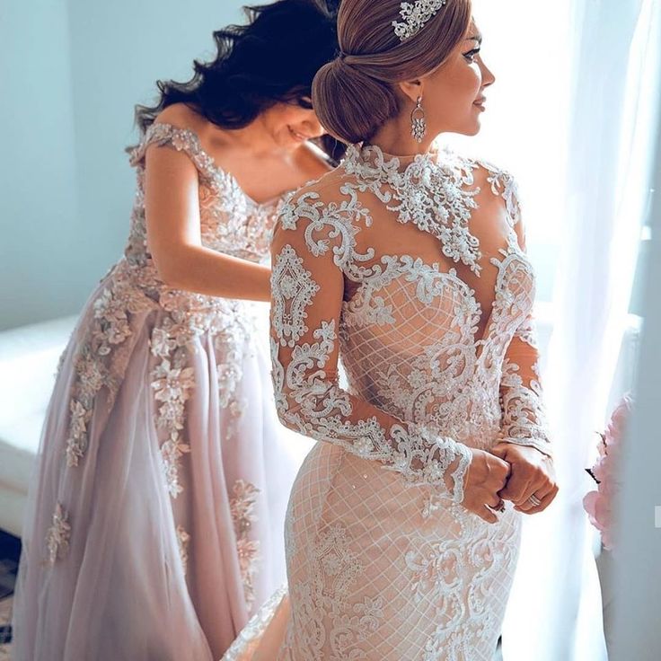 two women in wedding dresses looking at each other