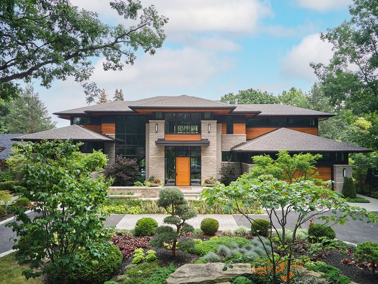 a large house with lots of trees and bushes in front of the entrance to it