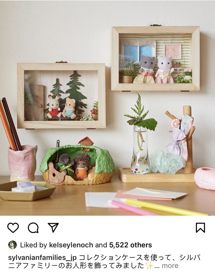 there are two wooden boxes with stuffed animals in them on the table next to other items