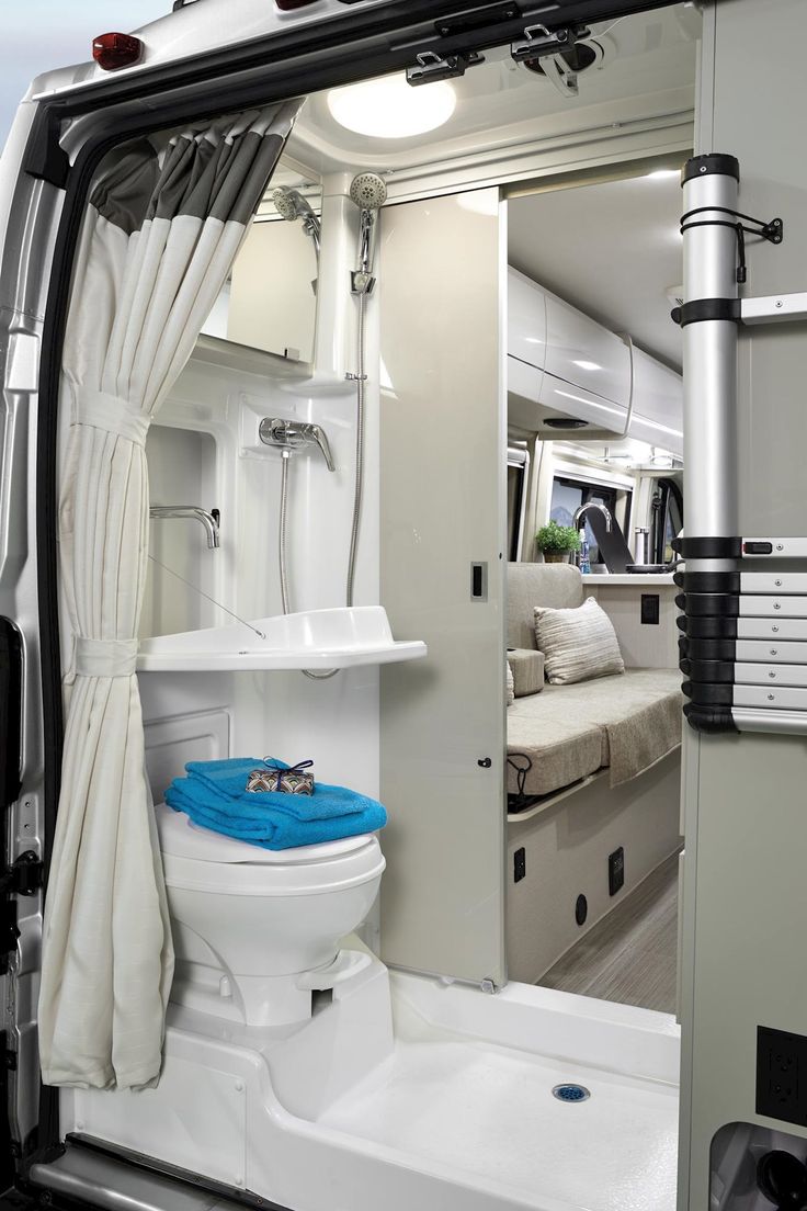 the interior of a camper with a toilet and sink in it's stall