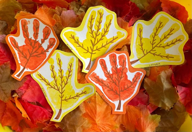 three stickers with leaves painted on them in the shape of handprints,