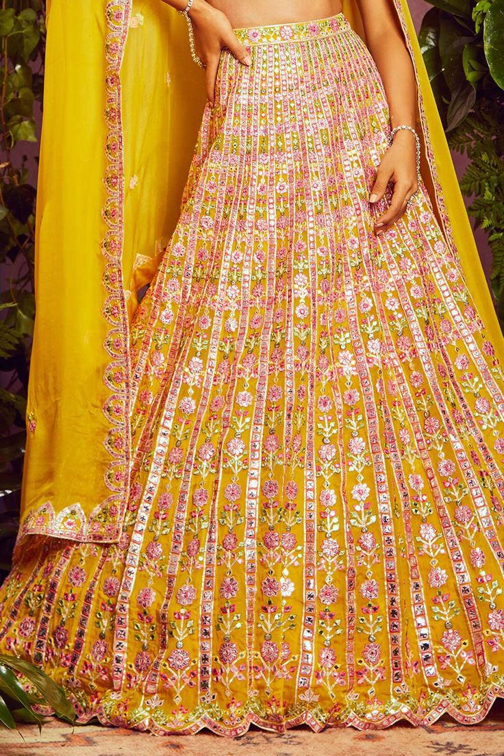 Yellow organza lehenga with all-over floral motif mirror-foil applique work and vertical striped detail. Comes with embroidered blouse and dupatta.
Component: 3
Embroidered
Neckline: V Neck
Sleeve Length: Sleeveless
Fabric: Soft Organza; Lining: Shantoon
Color: Yellow
Cutwork detail
V- back - Aza Fashions Yellow Wedding Dress With Dupatta, Yellow Floor-length Salwar Kameez For Reception, Yellow Floor-length Dupatta For Reception, Yellow Unstitched Gown With Dupatta, Floor-length Sharara With Sheer Dupatta For Festivals, Chanderi Wedding Dress With Gota Work, Wedding Chanderi Dress With Gota Work, Festival Floor-length Sharara With Sheer Dupatta, Floor-length Gota Work Set For Festivals