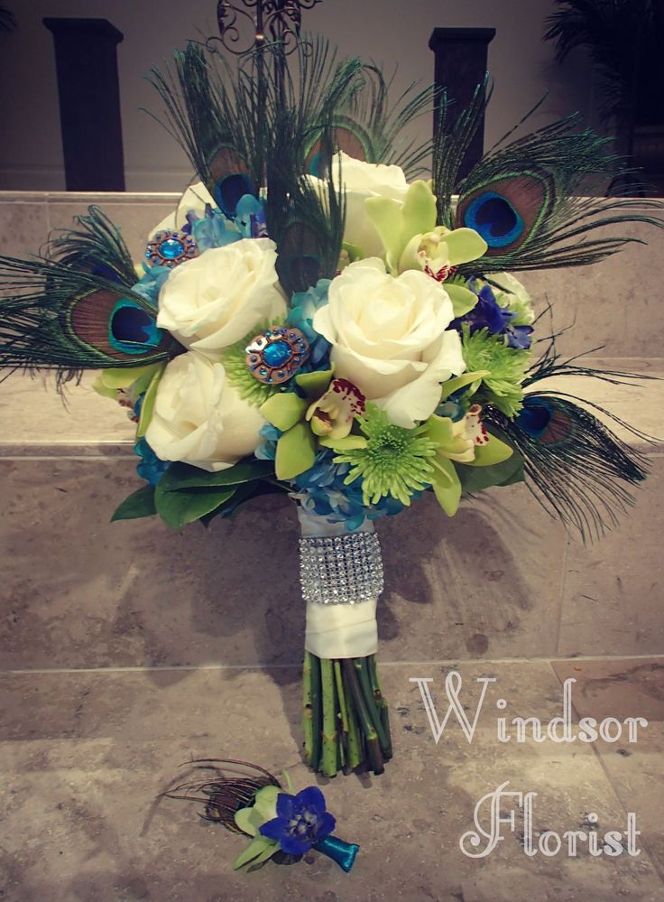 a bridal bouquet with peacock feathers and flowers on the steps in front of a building