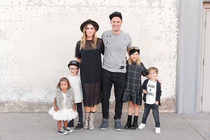 a family poses for a photo in front of a white wall