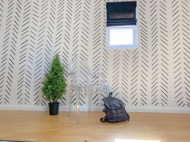 there is a small tree in the corner of this room with wallpaper and a window