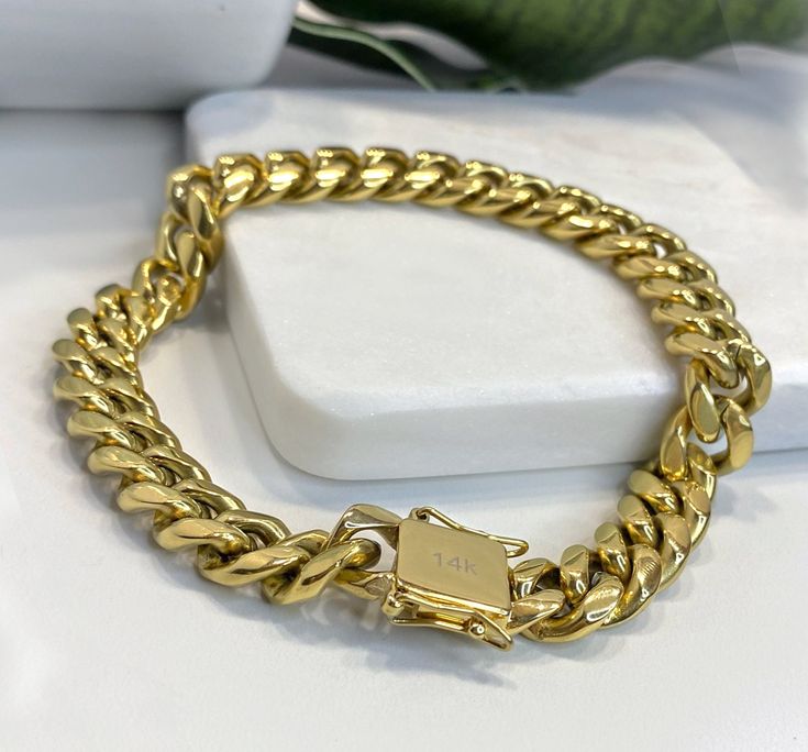 "Fashionable look of 10mm Miami Cuban Link Bracelet featuring double safety lock box clasp. Made of 14k gold filled. - Available Sizes: - Bracelet 10mm/7 Inches Long - Bracelet 10mm/8 Inches Long - Bracelet 10mm/9 Inches Long - Bracelet or Anklet 10mm/11 Inches Long 💎 With new products daily, quality and competitive prices, in DiJu Jewelry you find the most unique styles of modern designs, always looking for elegance and market trends. *Helping your Jewelry Businesses Grow *Starting your Own Bu Luxury Tarnish-resistant Yellow Gold Cuban Link Bracelet, Formal Gold Cuban Link Bracelet With Box Chain, Gold Link Jewelry With Box Clasp, Gold Rectangular Curb Chain Bracelets, Gold Cuban Link Chain Bracelet For Gift, Rectangular Gold Bracelets With Curb Chain, Gold Round Bracelets With Box Clasp, Gold-tone Jewelry With Box Clasp For Gift, Classic Gold Chain Cuban Link Bracelet As Gift