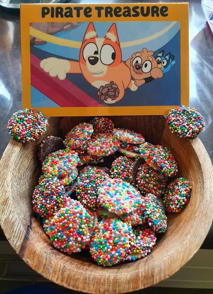 there is a bowl full of donuts with sprinkles on it and a sign that says pirate treasure