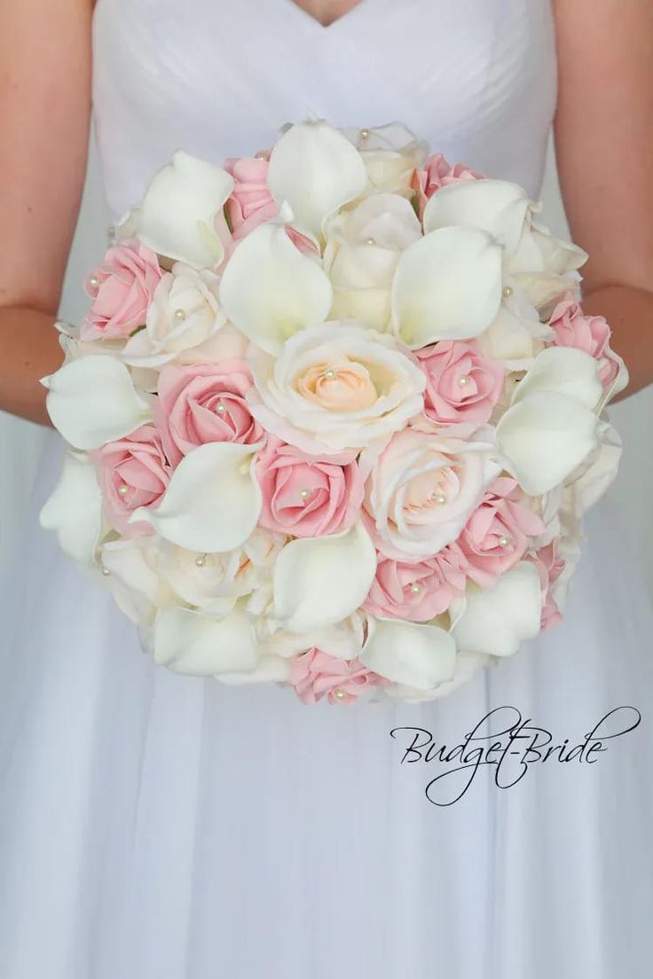 a bride holding a bouquet of white and pink flowers