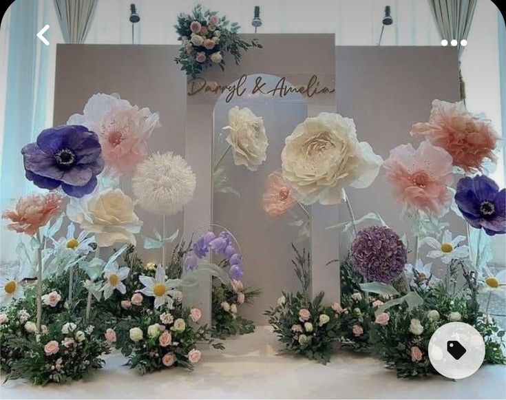 an arrangement of flowers on display in front of a sign